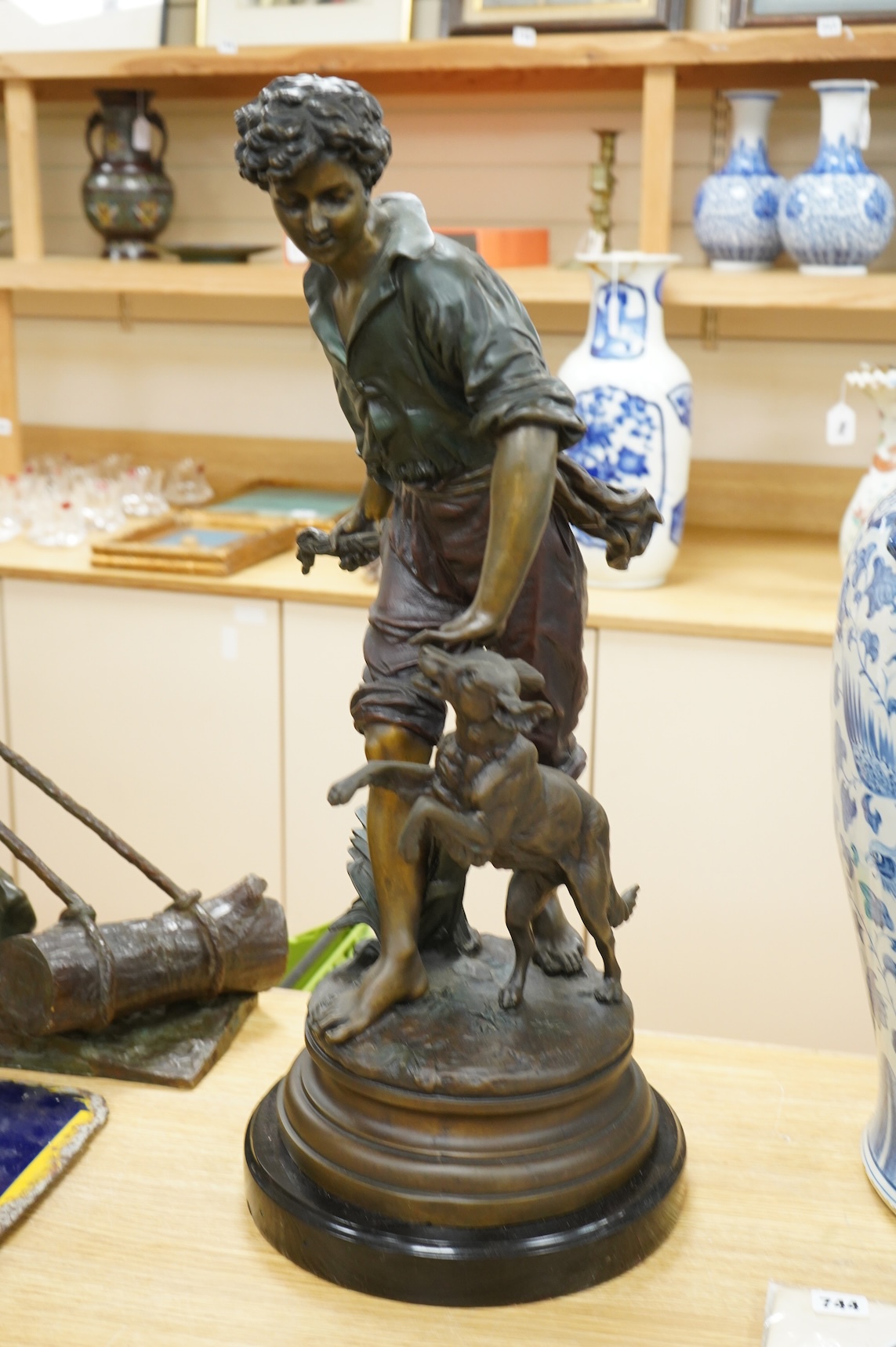 A large painted spelter model of a boy with a dog, on stand - 68cm high